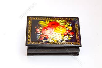 a small closed black box for small things and jewelry painted in the Russian style under the khokhloma on a white