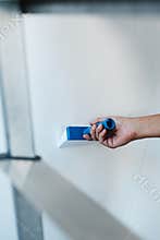 Spreads some glue with a brush on a wall
