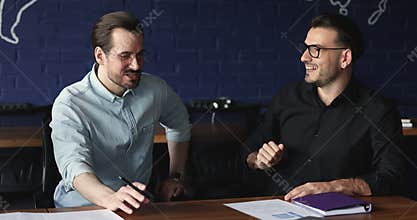Two successful businessmen discuss project or cooperation meet in office