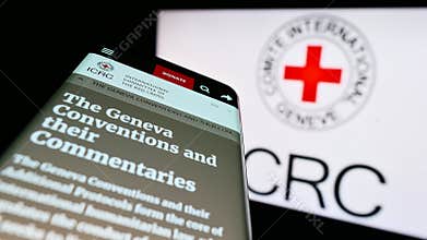 Mobile phone with website of International Committee of the Red Cross (ICRC) on screen in front of logo.