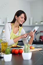 Woman using tablet in kitchen