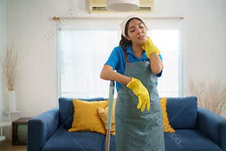 Exhausted Asian maid struggles with fatigue while mopping the house, showcasing the challenges and hard work behind domestic house