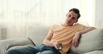 Man suffering from boredom in front of TV in the living room