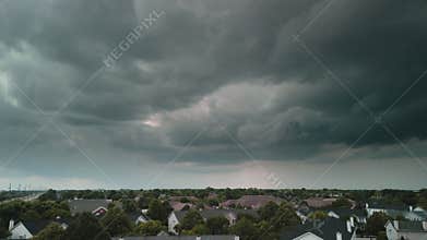 Stormy clouds forming on gloomy sky before heavy rainfall and lightning over suburban town area. Wide Time lapse