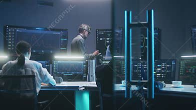 Team of IT technical specialists and software programmers work in monitoring office