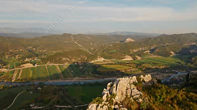 aerial scenic landscape with green fields, meadows, curved mountain river and mountain ridge with high mountains and