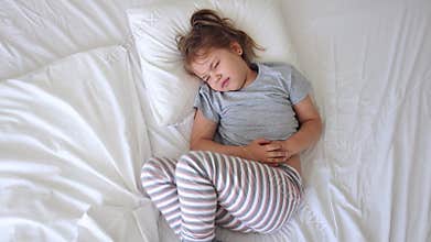 Child with stomach ache.Little girl suffering of belly pain. Caucasian kid health problems.