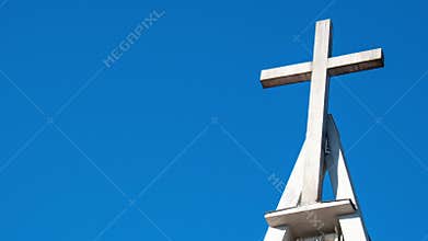 Zoom in out Christian church cross with bells on blue sky. Symbol of religion. Catholic church in Poland and bell tower