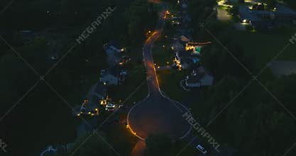 Residential illuminated homes at night in suburban sprawl development in Rochester, New York. Low-density two story