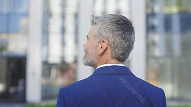 Back View of Caucasian Mature Businessman, Guy In Formal Suit, Standing In City Outdoors, Looking At Urban Buildings