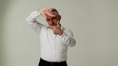 A middle aged man poses for a photography and video equipment advertisement. A man movie producer or photographer uses