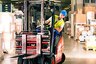 Forklift driver at warehouse of forwarding