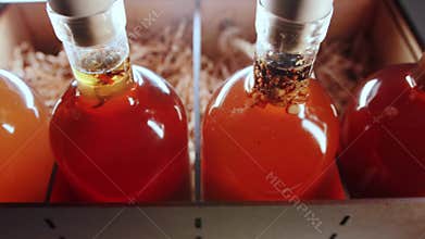 Herbal alcoholic tinctures in a wooden box, close-up. Elite collection alcohol brandy and cognac. Movement from the