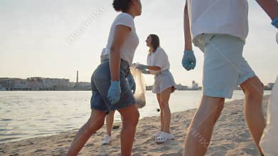 Group of eco-activist cleans garbage in nature. Young people collecting garbage in a plastic bag in nature. The concept
