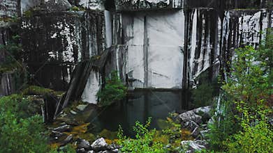 Drone fly backwards in abandoned white marble quarry in Carrara, Italy.
