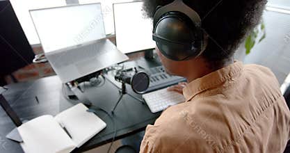 African american man in headphones podcasting at home, slow motion