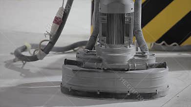 Concrete floor grinding machine. Concrete floor grinding with construction equipment. A worker creates a level concrete