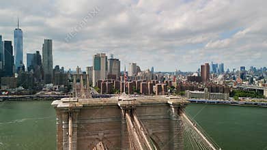 AERIAL shot over Brooklyn Bridge with American flag and East River view over Manhattan New York City Skyline