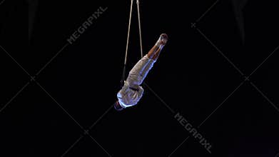 Muscular male air circus artist performances with dance trapeze