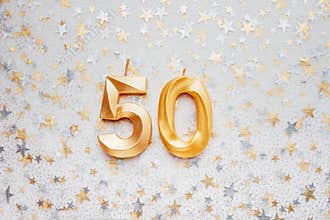 Number 50 fifty golden celebration birthday candle on Festive Background.