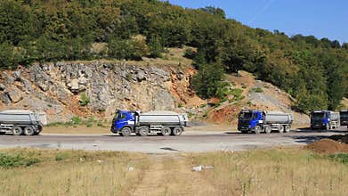 Group of trucks organized in a convoy transports cargo