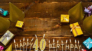 Happy birthday 40. Top view of the golden letters of the candle with the number happy birthday, the background of the gift boxes
