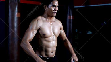 Athletic man with kettlebell dumbbell during cross training at fitness gym. Health and muscles flexing