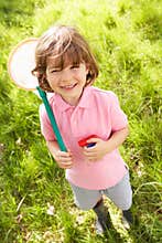 Young Boy In Field With Net And Bug Catcher