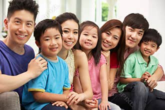 Two Chinese Families Sitting And Relaxing At Home