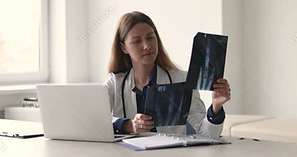 Woman doctor radiologist in white coat analyze x-rays images
