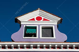 View of an atique window in an Italian house in Burano, Italy against a clear blue sky background