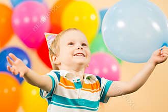 Happy kid boy with balloons on birthday party