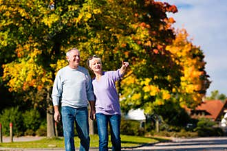 Seniors in autumn or fall walking hand in hand