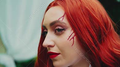 fantasy art portrait red-haired evil woman halloween makeup red bloody scars on face close-up. Vintage style white dress