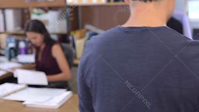 Male Architect Walks Through Office Talking With Colleagues