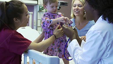 Mother And Daughter With Staff In Pediatric Ward Of Hospital