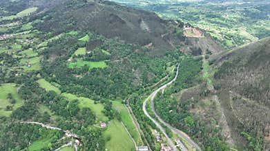 Aerial view of lush countryside with village, forest, and mountains, Infiesto, Asturia, Spain.