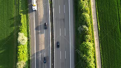 Birdeye footage of cars driving on the Autobahn 5 highway by green fields in Butzbach, Germany