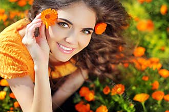 Beauty happy Romantic woman Outdoors. Beautiful Teenage girl embracing in golden marigold flowers
