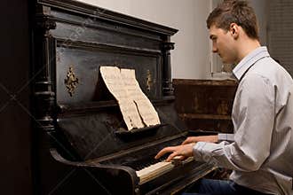 Young man practising at a piano