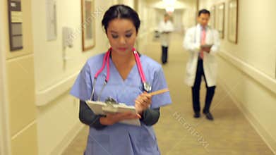 Medical Staff Working At Busy Nurses Station
