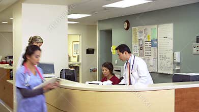 Medical Staff Working At Busy Nurses Station