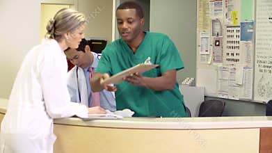 Medical Staff Working At Busy Nurses Station
