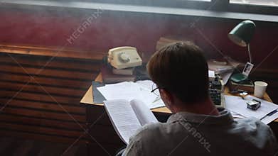 Young author thinking intensely in vintage office,
