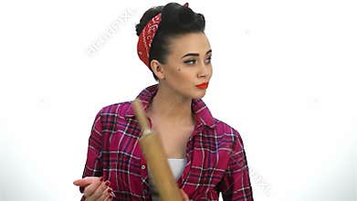 Fierce pin-up housewife wielding a battledore