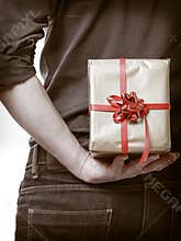 Holiday. Man hiding surprise gift box behind back