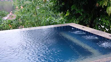 Tranquil Poolside with gentle ripples and underwater bubbles , surrounded by lush green trees