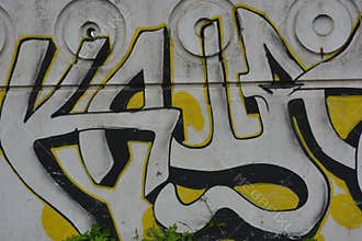 A bright,The graffiti depicting the word in Russian KASHAU, ????? is painted on a white and gray concrete fence.