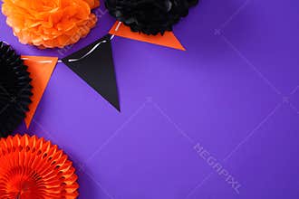 Colorful Halloween party decorations with paper flowers and triangle bunting on a bright purple back