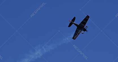 Stunt plane performing aerobatics and a low pass over the Swiss Alps